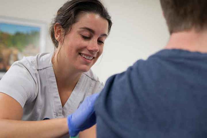 A nursing student administers a flu shot during a community clinic.