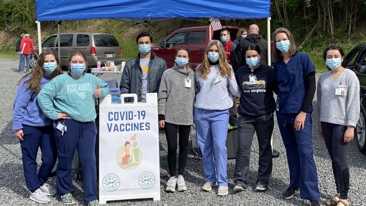 A group of student volunteers at a COVID vaccine tent