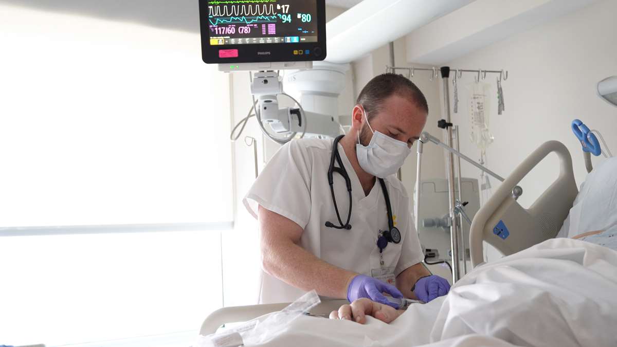 Nursing graduate Seth Burk delivers care to a patient.