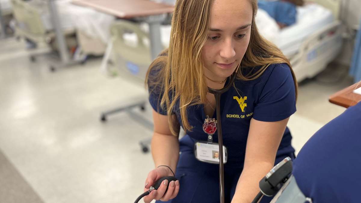 A nursing student practices taking blood pressure on a patient. 