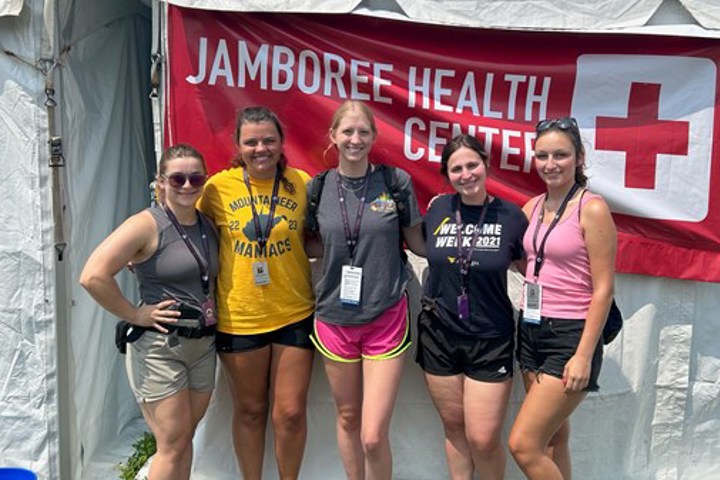 Five students stand in front of a white medical tent at the National Scouts Jamboree.